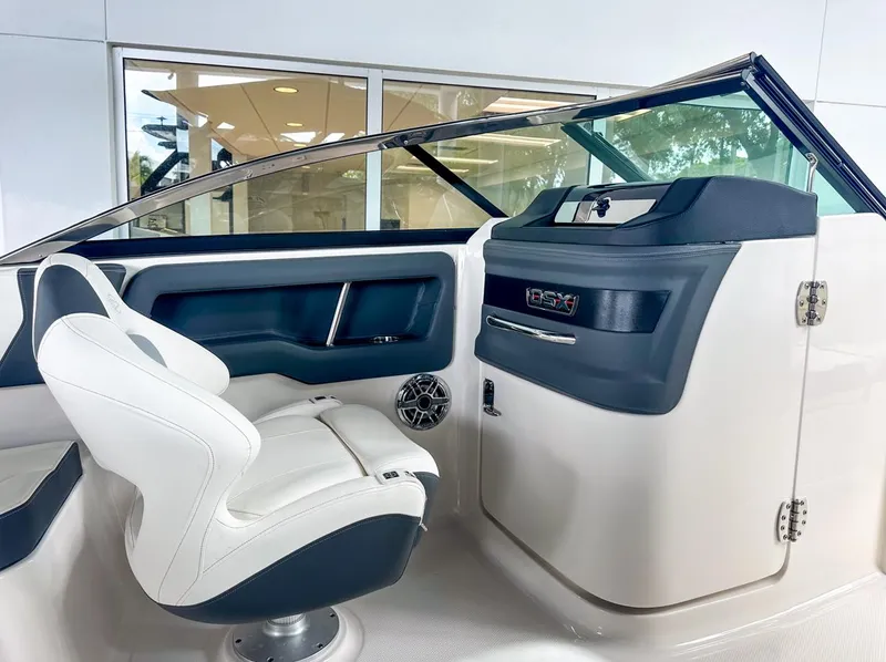 Slide: The Image of 2024 Chaparral 250 OSX OB boat interior with white seating and modern dashboard. - 21