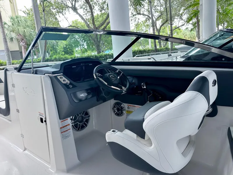 Slide: The Image of 2024 Chaparral 250 OSX OB boat interior with sleek dashboard and comfortable seating. - 22