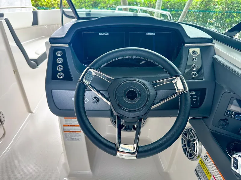 Slide: The Image of 2024 Chaparral 250 OSX OB helm with modern steering wheel and dual Simrad displays. - 25
