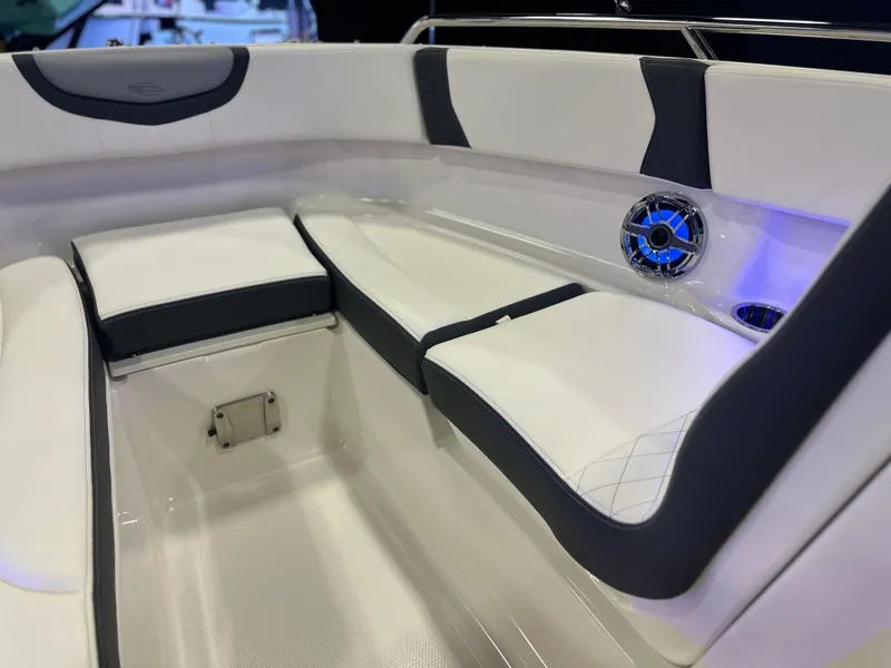Slide: The Image of 2024 Chaparral 250 OSX OB boat interior with white and gray seating, blue LED lighting. - 29