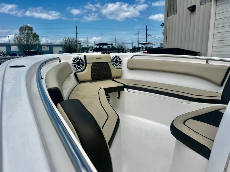 Slide: The Image of 2019 Tidewater 232 CC Adventure boat with beige seating and speakers, docked outdoors. - 8