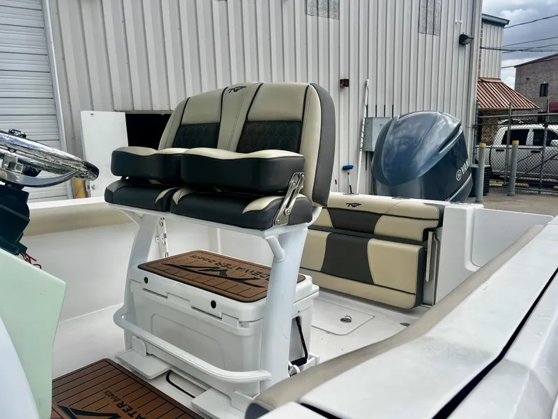 Slide: The Image of 2019 Tidewater 232 CC Adventure boat interior with cushioned seating and steering wheel. - 9