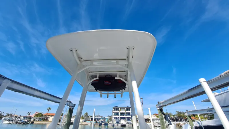 Slide: The Image of 2019 Boston Whaler 210 Montauk boat with T-top against a clear blue sky. - 12