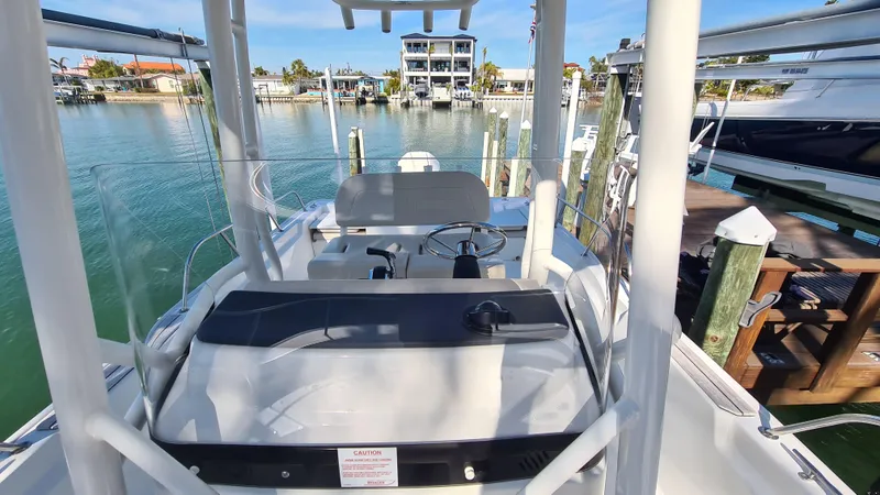 Slide: The Image of 2019 Boston Whaler 210 Montauk boat docked in a marina, showcasing helm and seating area. - 15