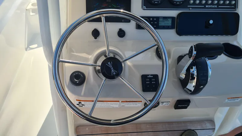 Slide: The Image of Steering wheel and controls of a 2019 Boston Whaler 210 Montauk boat. - 17