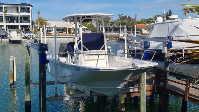 Slide: The Image of 2019 Boston Whaler 210 Montauk boat docked in a marina setting. - 2