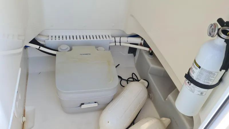 Slide: The Image of 2019 Boston Whaler 210 Montauk interior storage with equipment and fire extinguisher. - 27