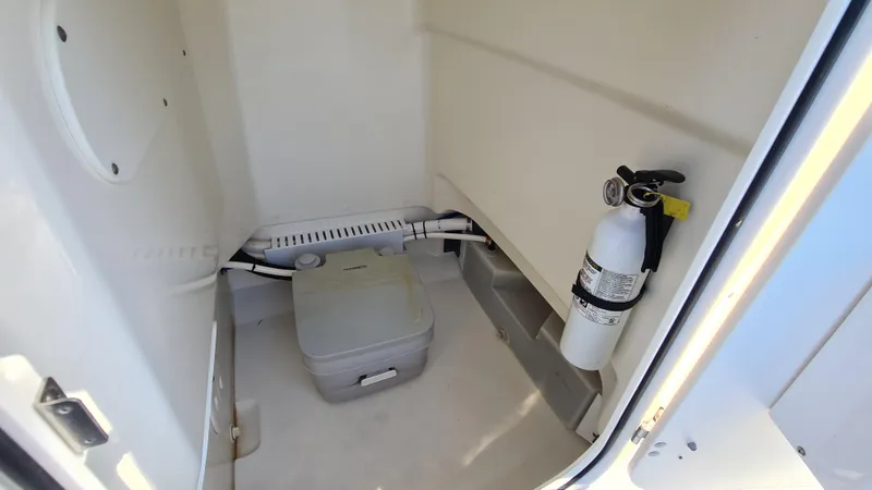 Slide: The Image of Interior of 2019 Boston Whaler 210 Montauk with portable toilet and fire extinguisher. - 28