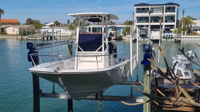 Slide: The Image of 2019 Boston Whaler 210 Montauk boat docked in a marina with waterfront homes. - 3