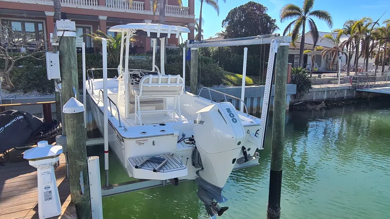 Slide: The Image of 2019 Boston Whaler 210 Montauk boat on lift, docked near palm trees. - 37