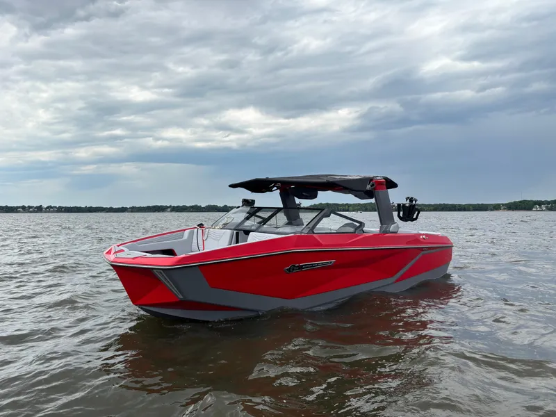 Slide: The Image of 2025 Nautique Super Air Nautique G25 boat on water, under cloudy sky. - 0