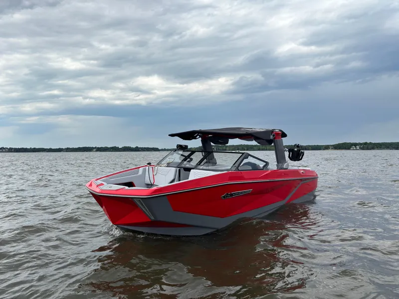 Slide: The Image of 2025 Nautique Super Air Nautique G25 boat on water under cloudy sky. - 1