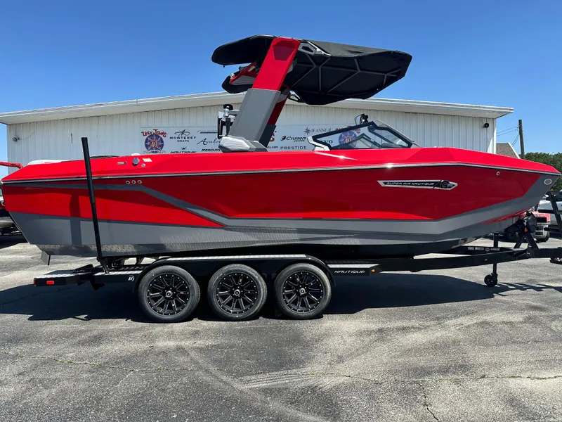 Slide: The Image of 2025 Nautique Super Air Nautique G25 boat in vibrant red on a trailer. - 10
