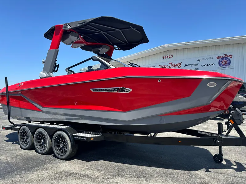 Slide: The Image of 2025 Nautique Super Air Nautique G25 boat in vibrant red on a trailer. - 12