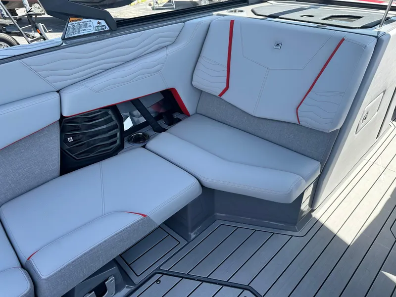 Slide: The Image of 2025 Nautique Super Air Nautique G25 interior with sleek gray seating and red accents. - 22