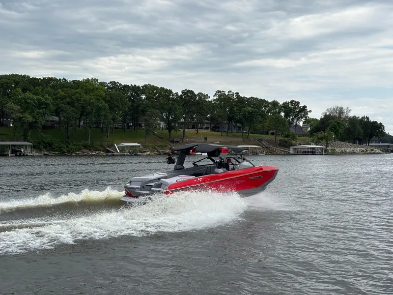Slide: The Image of 2025 Nautique Super Air Nautique G25 cruising on a lake under cloudy skies. - 3