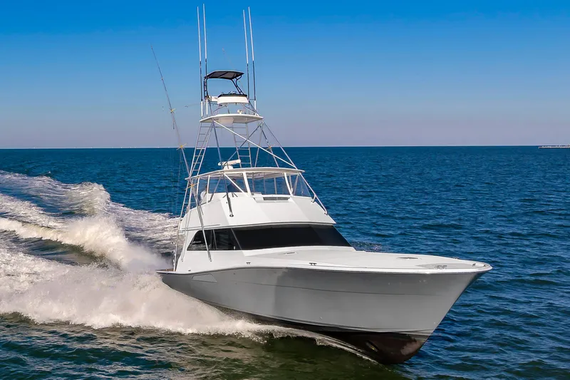 Slide: The Image of 1999 Viking 58 Convertible yacht cruising on open sea under clear blue sky. - 0