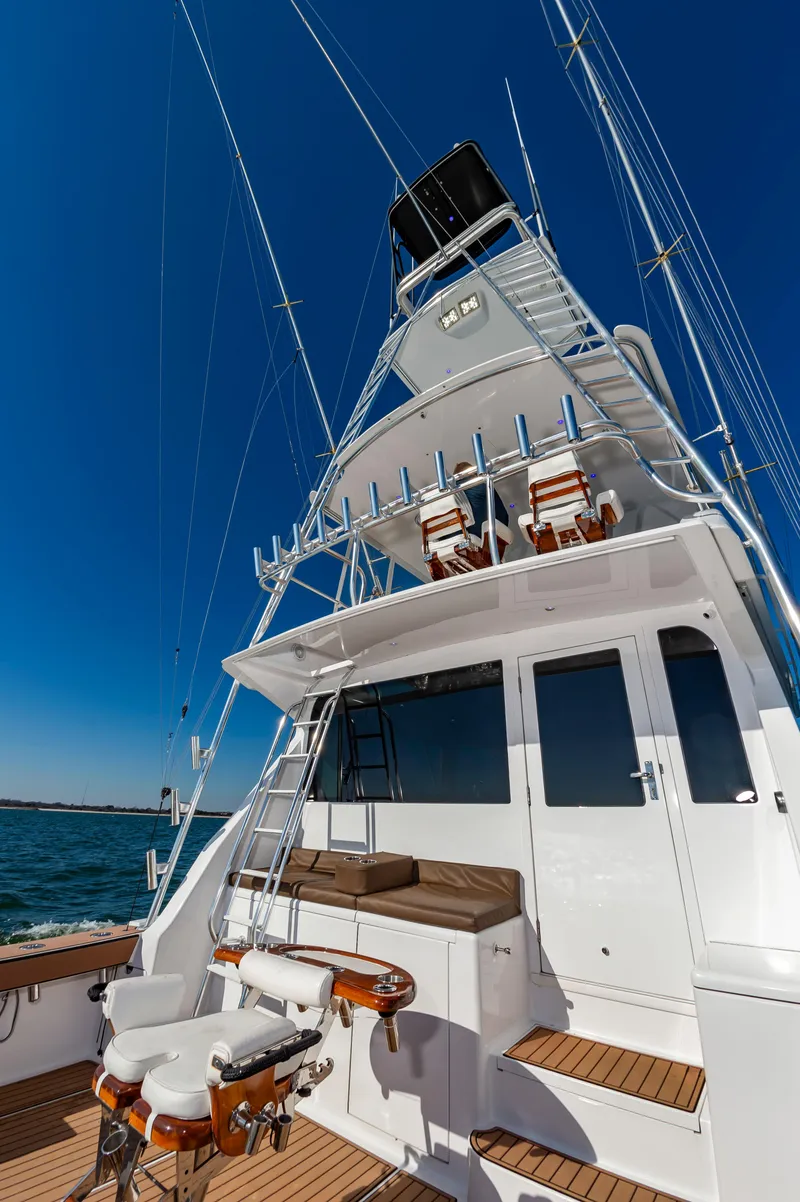 Slide: The Image of 1999 Viking 58 Convertible yacht with fishing chairs and tower against clear blue sky. - 21