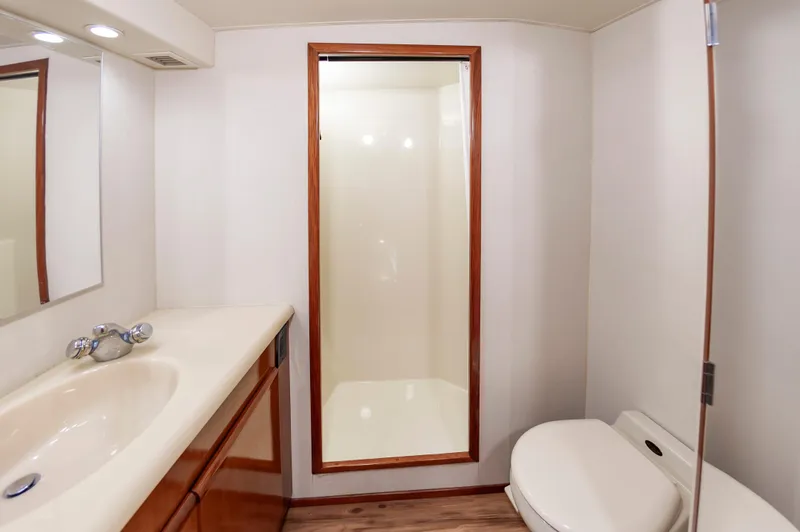 Slide: The Image of Bathroom interior of 1999 Viking 58 Convertible yacht, featuring shower, sink, and toilet. - 38