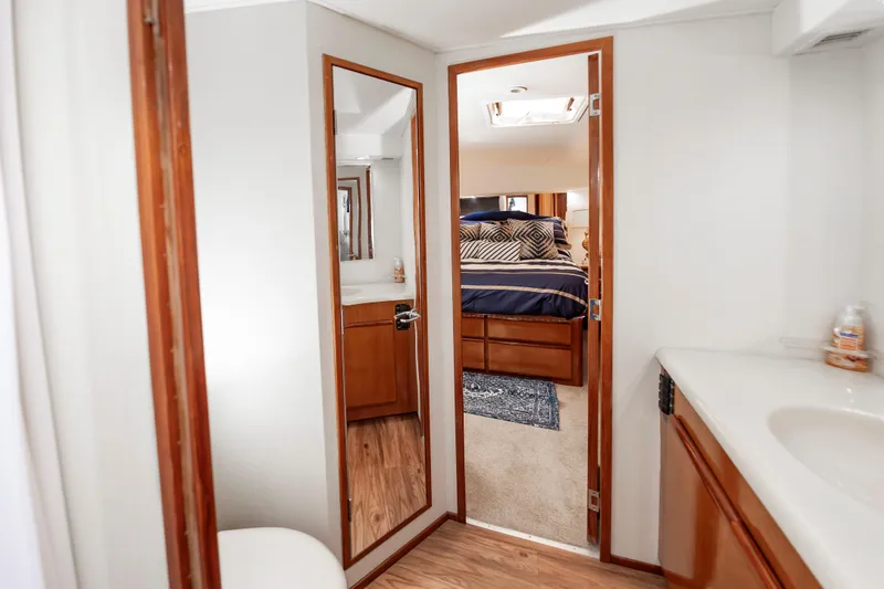 Slide: The Image of Interior of 1999 Viking 58 Convertible yacht, featuring a cozy bedroom and bathroom. - 41