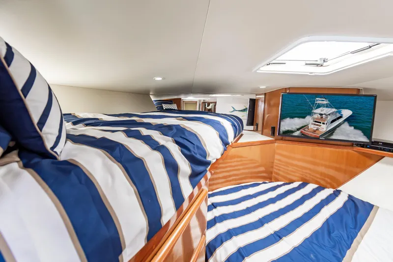 Slide: The Image of Interior of 1999 Viking 58 Convertible yacht with striped bedding and TV. - 46