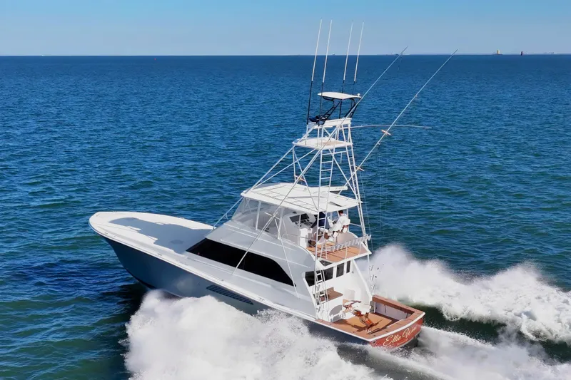 Slide: The Image of 1999 Viking 58 Convertible yacht cruising on open sea, creating waves. - 5