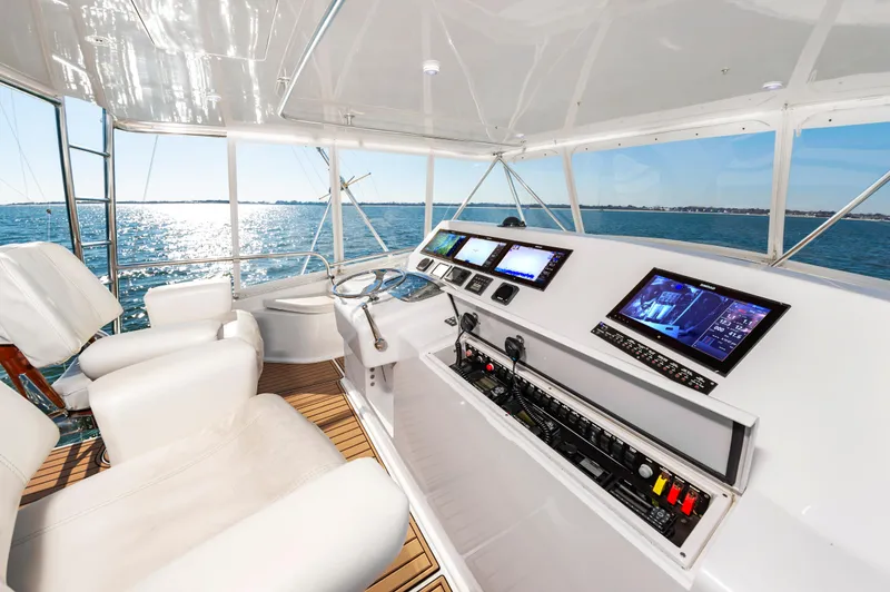 Slide: The Image of Helm of 1999 Viking 58 Convertible yacht with modern navigation displays on open water. - 9