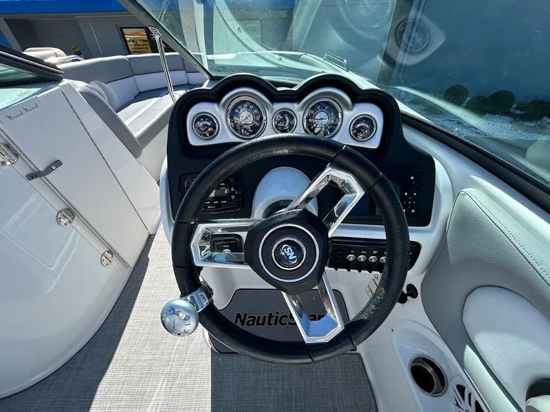 Slide: The Image of 2022 NauticStar 243DC Sport Deck boat dashboard with steering wheel and gauges. - 10