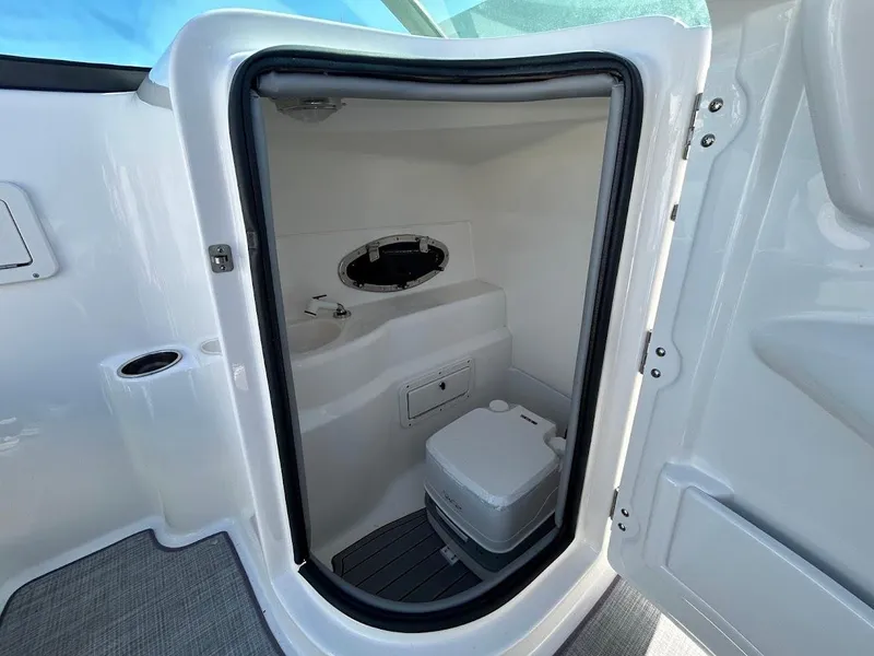 Slide: The Image of Interior view of 2022 NauticStar 243DC Sport Deck boat's compact bathroom. - 13