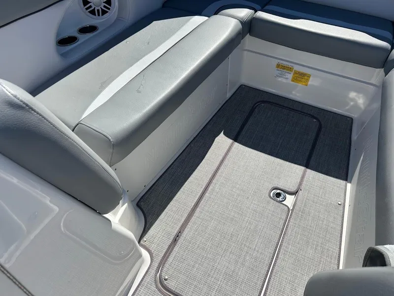 Slide: The Image of 2022 NauticStar 243DC Sport Deck interior seating with gray upholstery and storage compartment. - 15