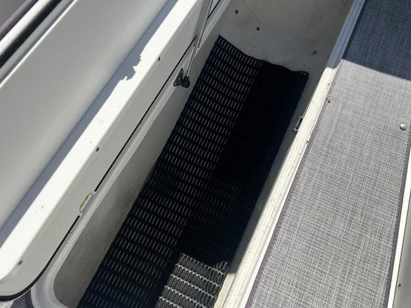 Slide: The Image of 2022 NauticStar 243DC Sport Deck storage compartment with textured flooring. - 16
