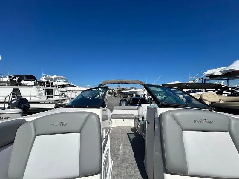Slide: The Image of 2022 NauticStar 243DC Sport Deck boat at a marina under clear blue skies. - 17