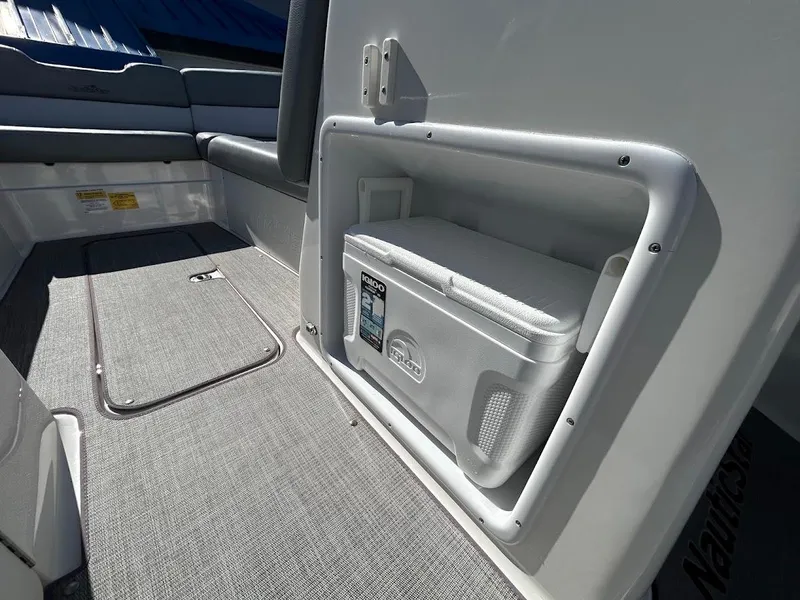 Slide: The Image of 2022 NauticStar 243DC Sport Deck interior with built-in cooler and seating. - 18