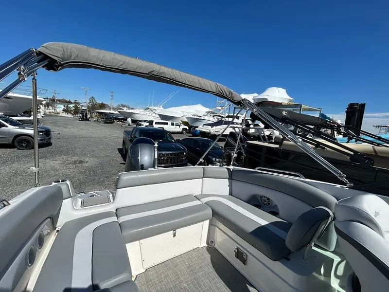 Slide: The Image of 2022 NauticStar 243DC Sport Deck boat with seating, parked in a marina under clear blue skies. - 19