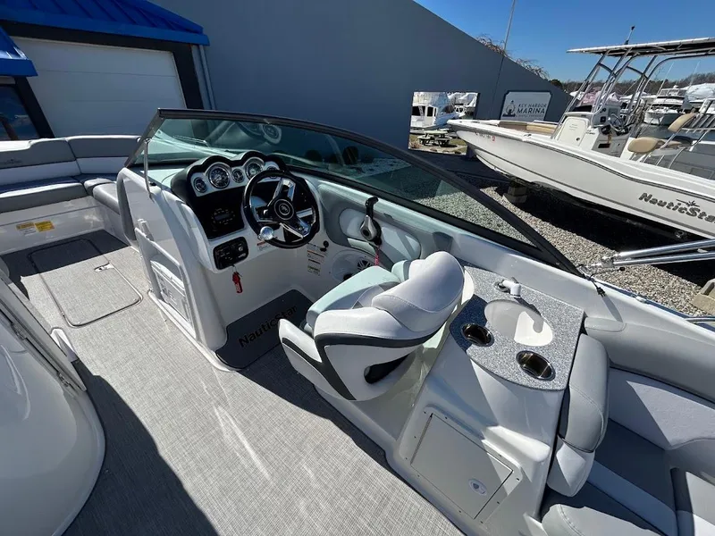 Slide: The Image of 2022 NauticStar 243DC Sport Deck boat interior with steering wheel and seating. - 7