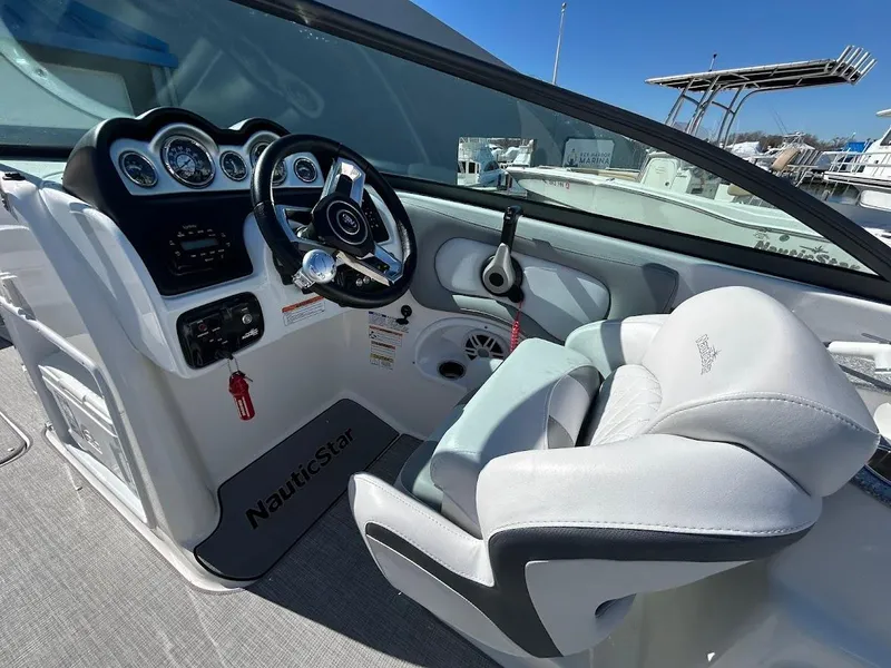 Slide: The Image of 2022 NauticStar 243DC Sport Deck boat interior with steering wheel and dashboard. - 8