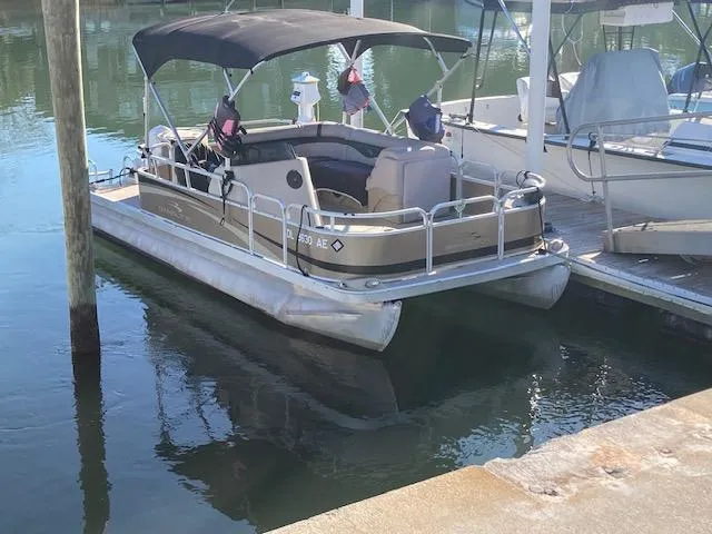 The Image of 2011 Bennington 20 GL pontoon boat docked in calm marina waters. - 1