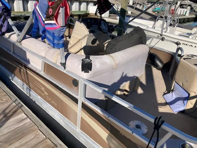 Slide: The Image of 2011 Bennington 20 GL pontoon boat docked with life jackets and seating visible. - 2