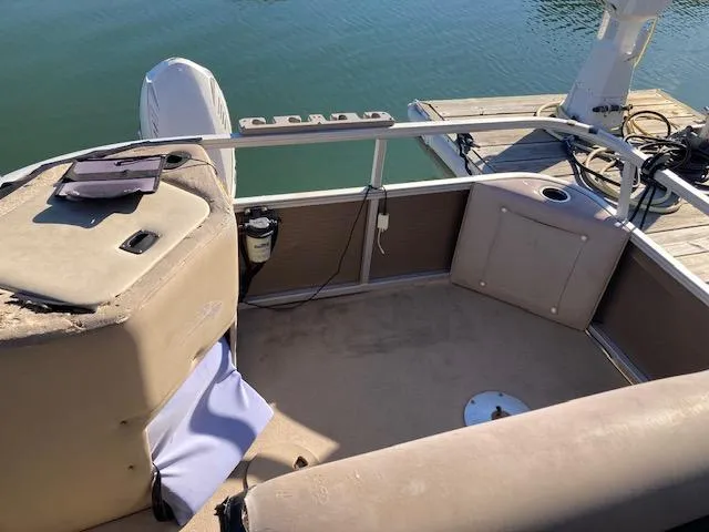 Slide: The Image of 2011 Bennington 20 GL pontoon boat interior near dock, featuring beige seating and railing. - 3