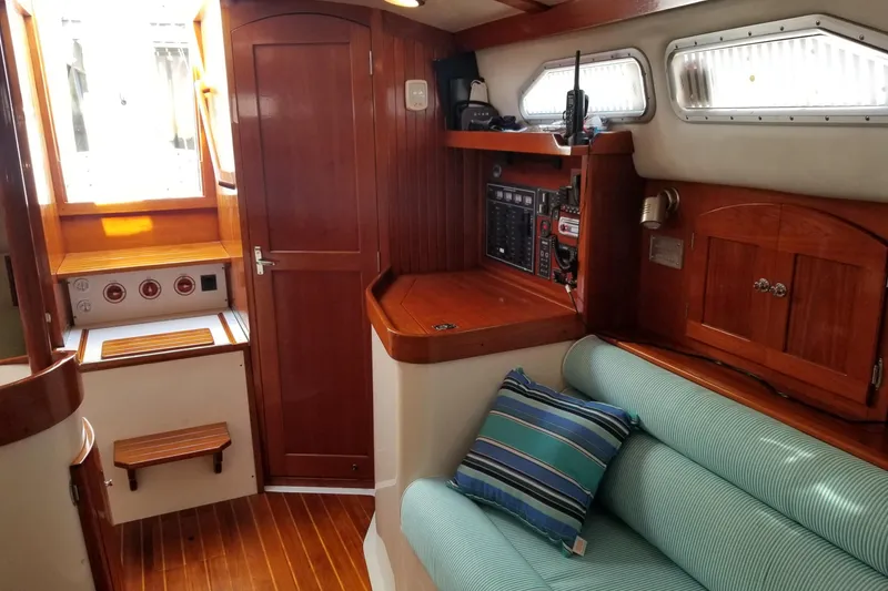 Slide: The Image of 2005 Shannon Shoalsailer interior with wood finish, striped cushion, and navigation equipment. - 15
