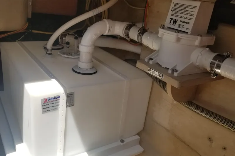 Slide: The Image of Boat plumbing system in a 2005 Shannon Shoalsailer, featuring a white tank and connected pipes. - 19