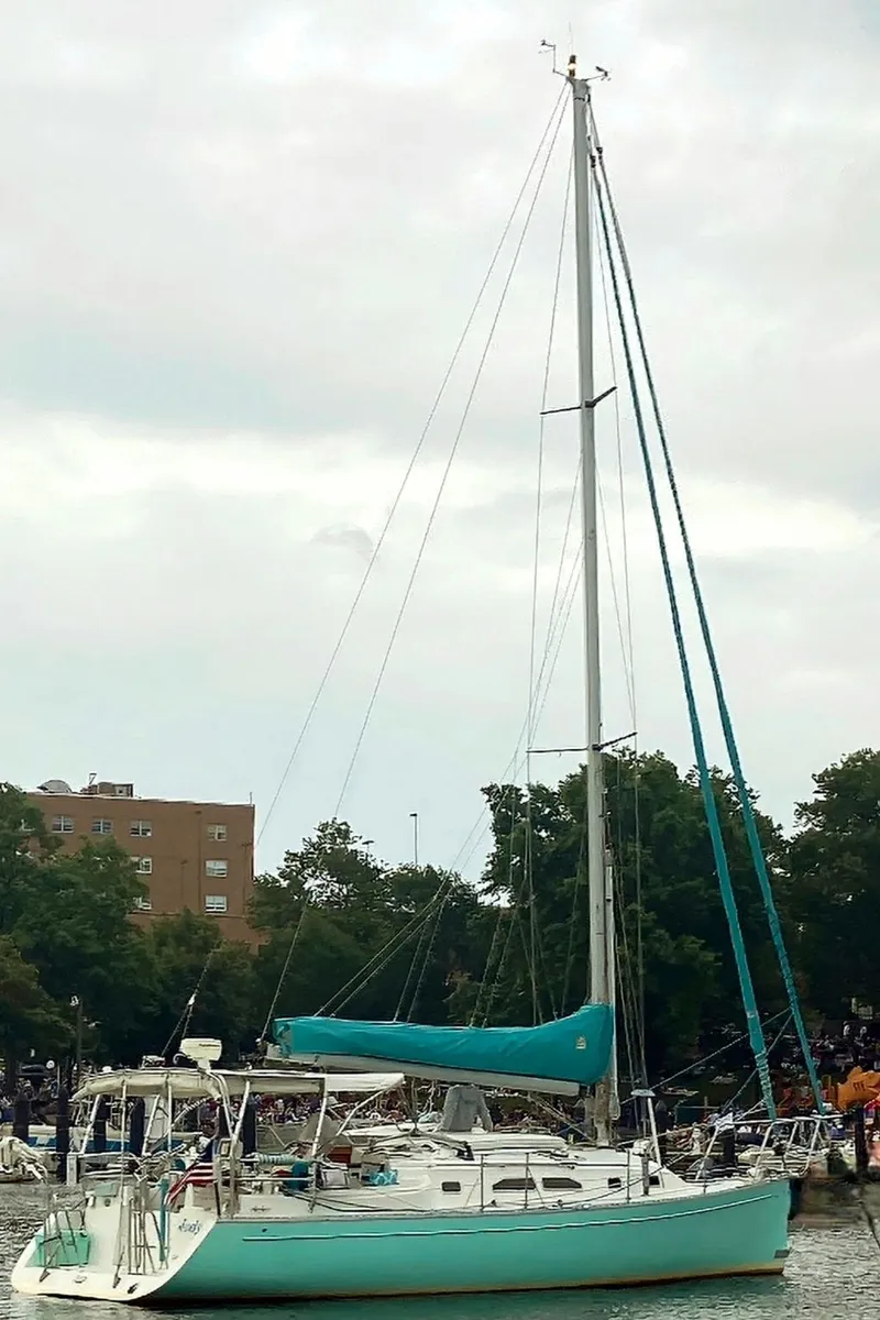 Slide: The Image of 2005 Shannon Shoalsailer sailboat docked in a marina with teal accents. - 25