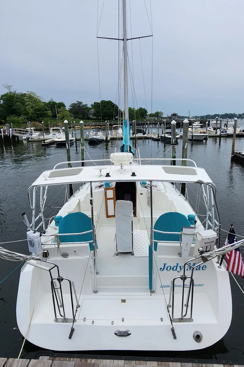 Slide: The Image of 2005 Shannon Shoalsailer docked at marina, rear view, with American flag. - 6