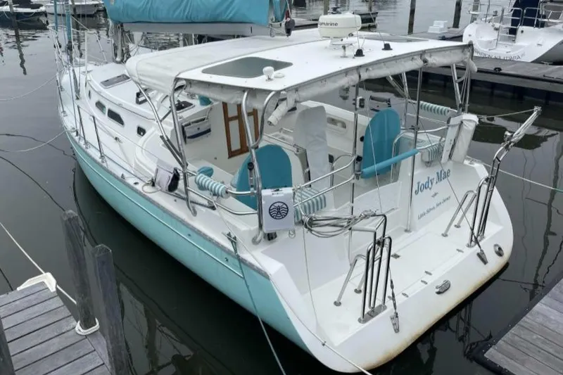 Slide: The Image of 2005 Shannon Shoalsailer docked sailboat with turquoise accents and covered cockpit. - 7