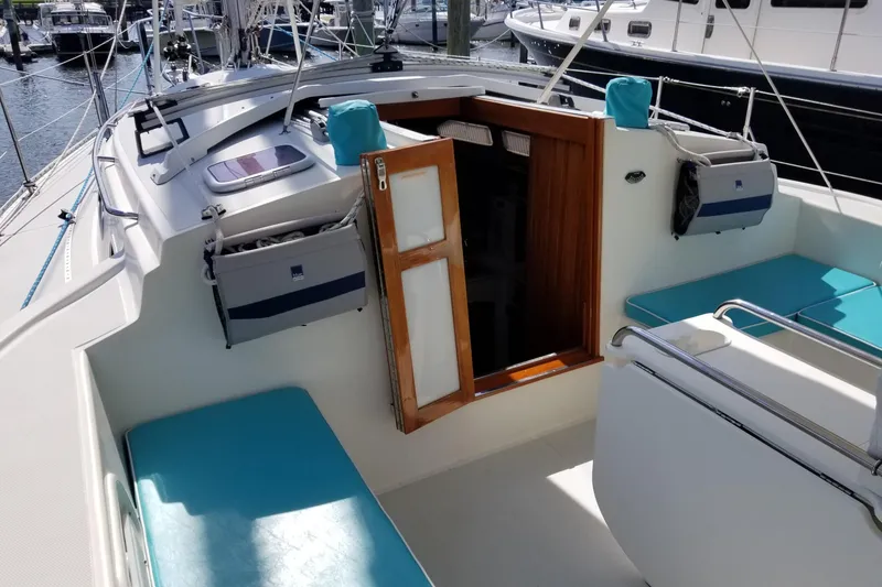 Slide: The Image of 2005 Shannon Shoalsailer sailboat cockpit with turquoise cushions and wooden cabin door. - 8