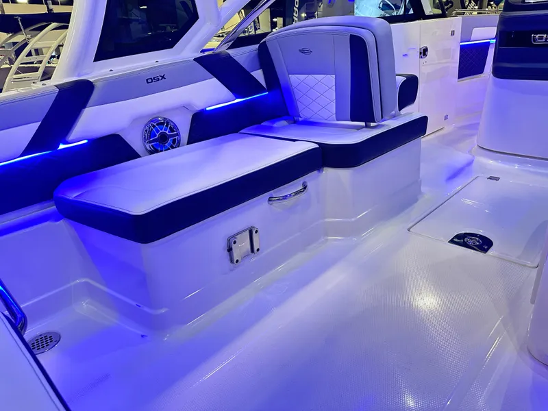 Slide: The Image of 2025 Chaparral 310 OSX boat interior with blue LED lighting and cushioned seating. - 11