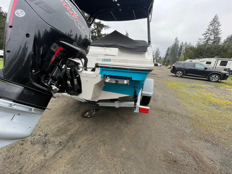 Slide: The Image of 2023 Bayliner VR4 Bowrider OB on trailer, featuring outboard motor, parked outdoors. - 23