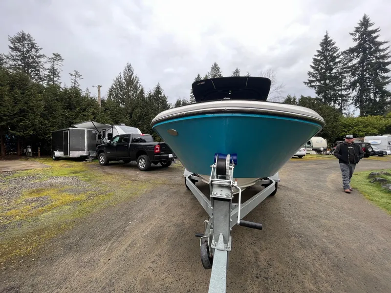 Slide: The Image of 2023 Bayliner VR4 Bowrider OB on trailer in outdoor setting with trees and vehicles. - 25