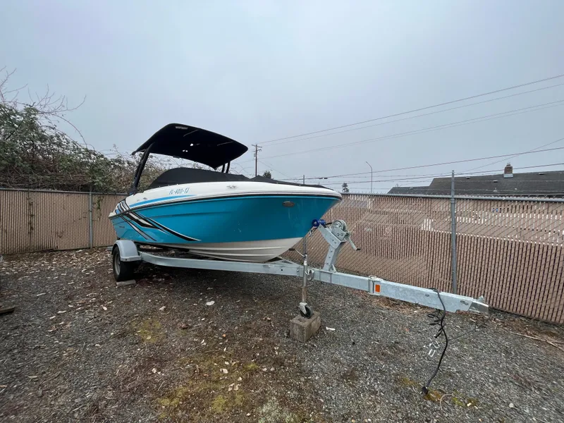 Slide: The Image of 2023 Bayliner VR4 Bowrider OB on trailer, blue hull, parked outdoors. - 26