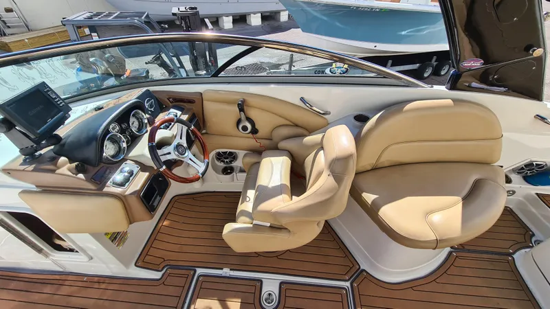Slide: The Image of 2018 Crownline Eclipse E24 XS boat interior with tan leather seats and wooden flooring. - 10